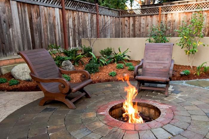 Место для костра в виде углубления, оформленное кирпичной выкладкой, гармонично дополнит ландшафтный дизайн участка