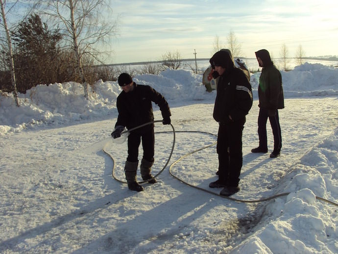 Заливка зимнего катка на дачной территории из поливочного шланга